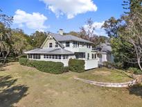 Charming two-story home featuring a screened porch, lush landscaping and a metal roof at 340 W 9Th Ave, Mount Dora, FL 32757