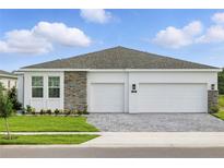 Charming single-Gathering home featuring a two-car garage, stone accents, and a well-manicured lawn at 4110 Gooseberry Trl, Kissimmee, FL 34746