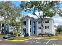 Well-maintained condo building with blue and grey exterior paint, reserved parking, and mature trees at 4304 Clubside Dr # 4304, Longwood, FL 32779