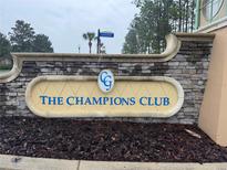 Elegant stone signage at The Champions Club community entrance creates a great first impression for residents and visitors at 8950 Azalea Sands Ln # 8950, Champions Gate, FL 33896