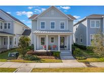 Charming two-story home with a welcoming front porch and well-manicured landscaping at 896 Tilden Oaks Trl, Winter Garden, FL 34787