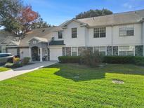 Charming townhouse with a well-manicured lawn and stone accents, offering a welcoming curb appeal at 923 Lexington Pkwy # 14, Apopka, FL 32712