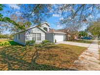 Charming single-story home with manicured lawn, mature trees, and a two-car garage at 11532 Rouse Run Cir, Orlando, FL 32817