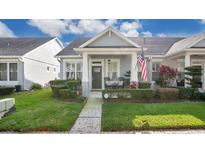 Charming home with a cozy front porch, manicured lawn, and an American flag waving proudly at 14072 Wild Majestic St, Orlando, FL 32828