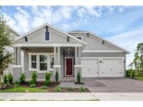 Charming single-story home featuring a red front door, a two-car garage, and meticulously landscaped front yard at 15491 Lebeau Loop, Winter Garden, FL 34787