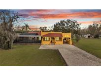 Charming home exterior featuring a screened pool and a spacious front yard and driveway at 1775 Druliner Rd, St Cloud, FL 34771