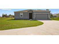 Charming single-story home featuring a well-manicured lawn and a two-car garage with a concrete driveway at 429 Ohio Way, Kissimmee, FL 34759
