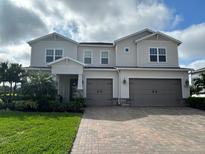 Two-story home boasts a paved driveway and a two-car garage, enhancing its curb appeal at 4690 Marina Row Drive, Orlando, FL 32820