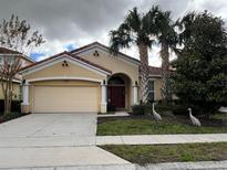 Charming single-story home with a terra cotta tile roof, well-manicured lawn, and a two-car garage at 5356 Oakbourne Ave, Davenport, FL 33837