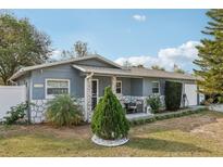 Charming single-story home with a cozy front porch and stone accents enhancing the curb appeal at 1004 Sunwood Ln, Orlando, FL 32807