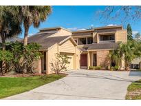 Inviting two-story home featuring a spacious driveway, attached garage, and lush tropical landscaping under a bright blue sky at 229 Springside Rd, Longwood, FL 32779