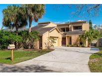 Charming two-story home with tan siding, brick accents, mature landscaping, and a spacious driveway at 229 Springside Rd, Longwood, FL 32779