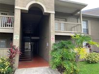 Exterior shot of the building featuring a tan exterior, stairs, and a small balcony at 285 Wymore Rd # 204, Altamonte Springs, FL 32714