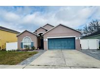 Charming single Gathering home with large garage and manicured front yard with blue shutters and blue garage door at 7214 Rex Hill Trl, Orlando, FL 32818