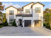 Stunning two-story home with a symmetrical facade, a paver driveway, and a two-car garage at 7465 Gathering Loop, Reunion, FL 34747