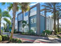 Modern townhome exterior with blue and gray siding, palm trees, and well-maintained landscaping at 7770 Sandy Ridge Dr # 212 Bldg 27, Kissimmee, FL 34747