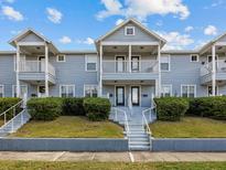 Charming two-story townhouse with well-maintained landscaping, front balcony and inviting entrance at 945 N Fern Creek Ave # 3, Orlando, FL 32803