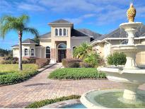 Stunning two-story home featuring manicured landscaping and elegant fountain in the front yard at 12625 Sweet Hill Rd, Polk City, FL 33868