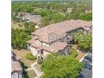 Aerial view of the condominium complex featuring a terracotta roof and ample parking at 13941 Fairway Island Dr # 733, Orlando, FL 32837