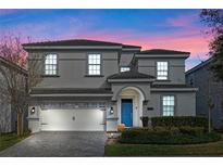 Charming two-story home with a well-manicured lawn and a striking blue front door at 1585 Plunker, Davenport, FL 33896