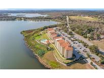 Stunning aerial view of lakeside condos featuring a pool, parking, and beautiful landscaping at 16300 County Road 455 # 712, Montverde, FL 34756