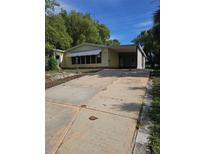 Charming single-story home with a covered carport and an expansive concrete driveway at 1765 W Schwartz Blvd, Lady Lake, FL 32159