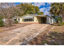 Charming single-story home featuring a long driveway and inviting curb appeal at 1765 W Schwartz Blvd, Lady Lake, FL 32159