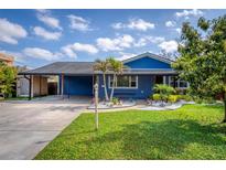 Charming blue home featuring a landscaped front yard, carport, and inviting curb appeal at 328 Lake Fair Ln, Winter Park, FL 32789