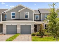Charming townhome featuring a two-car garage, well-maintained landscaping, and a welcoming entrance at 399 Sequoia Dr, Lake Wales, FL 33859