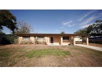 Charming single-story home featuring a carport, well-maintained lawn, and welcoming entrance at 702 Apricot Dr, Ocoee, FL 34761