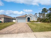 Charming single Gathering home with a well manicured lawn, brick driveway and craftsman style elevation at 1038 Commuter Dr, Deltona, FL 32738