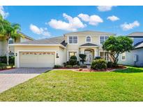 Charming two-story home featuring a lush green lawn, well-maintained landscaping, and an attached two-car garage at 137 Kays Landing Dr, Sanford, FL 32771