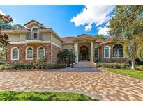 Stunning home featuring a brick driveway, stone accents, and arched windows at 1502 Hempel Ave, Windermere, FL 34786