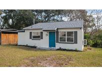 Charming home featuring a well-kept lawn, crisp white exterior, and a bright blue front door at 19 N Van Buren Ave, Orlando, FL 32811