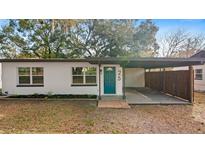 Charming single-story home featuring a teal-colored front door, carport, and freshly painted white exterior at 25 N Van Buren Ave, Orlando, FL 32811