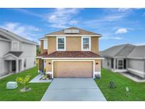 Charming two-story home with a well-maintained lawn and attached two-car garage at 259 Southbridge Cir, Kissimmee, FL 34744