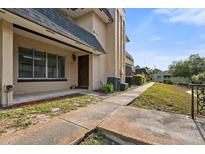 Exterior view of a two story home with a walkway leading to the front door and a grass area at 5415 Fairwood Way # 303, Orlando, FL 32808