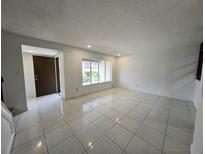 Bright, open living room featuring tile floors and a large window for natural light at 5415 Fairwood Way # 303, Orlando, FL 32808