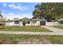 Charming single-story home featuring a well-maintained lawn, dark garage door, and welcoming curb appeal at 7331 Blue Jacket W Pl, Winter Park, FL 32792