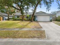 Charming home with mature trees, a two-car garage, and a well-maintained lawn at 851 Benchwood Dr, Winter Springs, FL 32708