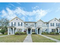 Charming townhome with well-manicured lawn, blue shutters, and inviting entryway at 8933 Newmarket Dr, Windermere, FL 34786