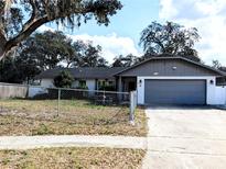 Charming single-story home with a well-maintained lawn and a classic design, featuring an attached garage and mature landscaping at 9436 Montello Dr, Orlando, FL 32817