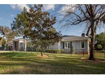 Beautiful home exterior featuring well-manicured lawn, mature landscaping, and charming architectural details at 105 Pine Street, Windermere, FL 34786