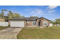 Charming one-story home with a two-car garage and a well-manicured lawn at 112 Lake Butler Ave, Haines City, FL 33844