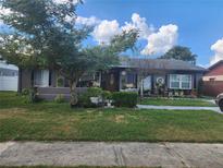 Charming single-story home with a well-manicured front yard and beautiful mature trees at 11419 Aries Dr, Orlando, FL 32837