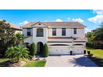 Beautiful two-story home featuring lush landscaping, a barrel tile roof and a three-car garage at 1581 Canopy Pasture Dr, St Cloud, FL 34771