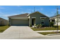 Charming one-story home featuring a well-manicured lawn and attached two-car garage at 313 Estates Ct, Haines City, FL 33844