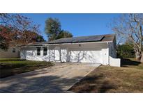Bright exterior of home featuring a large driveway and a two-car garage door at 50 Avalon Ct, Casselberry, FL 32707