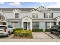 Charming townhome with a light blue facade, dark shutters, and a well-manicured front yard at 7659 Sir Kaufmann Ct, Kissimmee, FL 34747