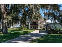 Inviting two-story home with well-manicured lawn, mature trees, and a private driveway at 9575 Ne 306Th Ct, Fort Mc Coy, FL 32134